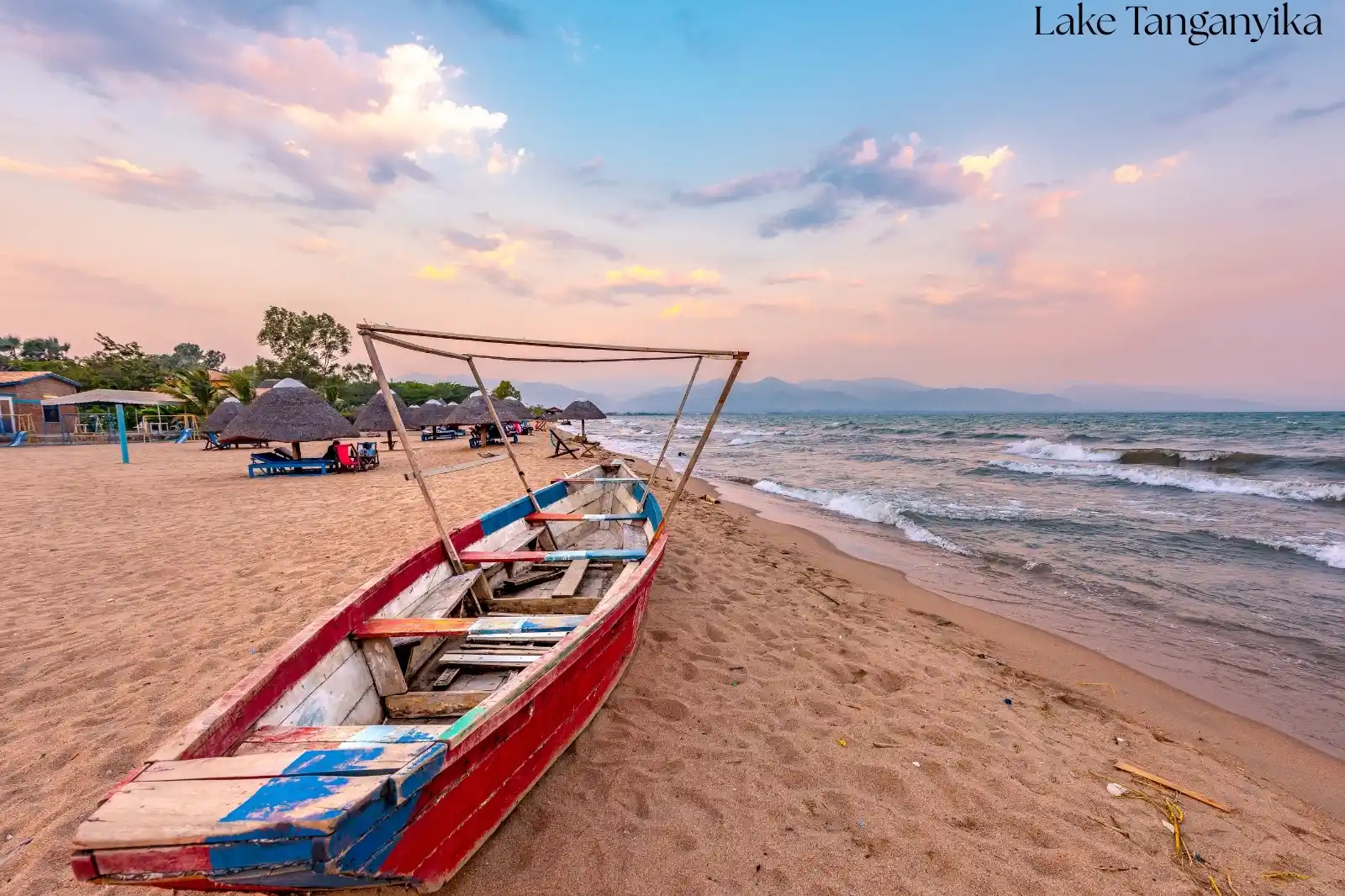 Traditional wooden boat resting on the pristine beach at Lake Tanganyika